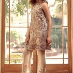 A beige top adorned with gold, silver and a pop of red colored gota work.